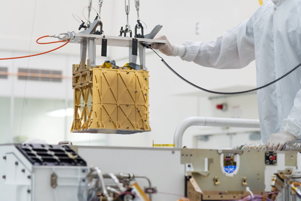 NASA技术人员将试验性的MOXIE仪器放入毅力号探测车